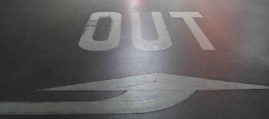 The word "OUT" painted on a road.