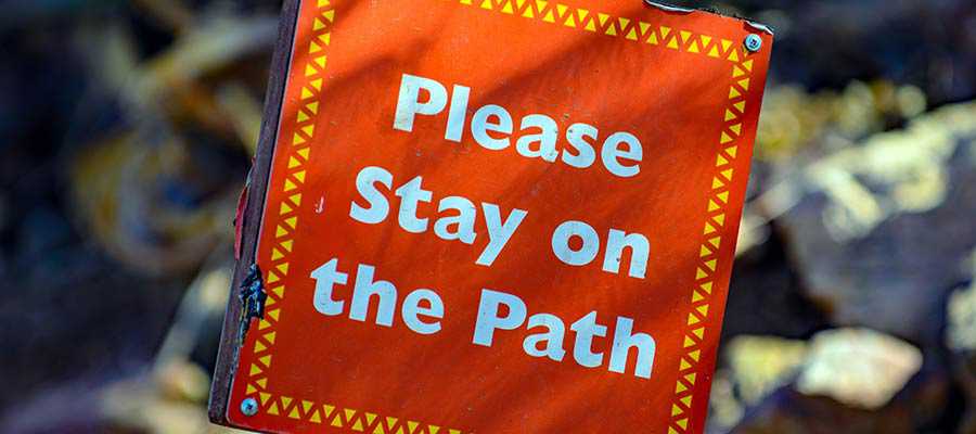 A sign that reads, "Please Stay on the Path".